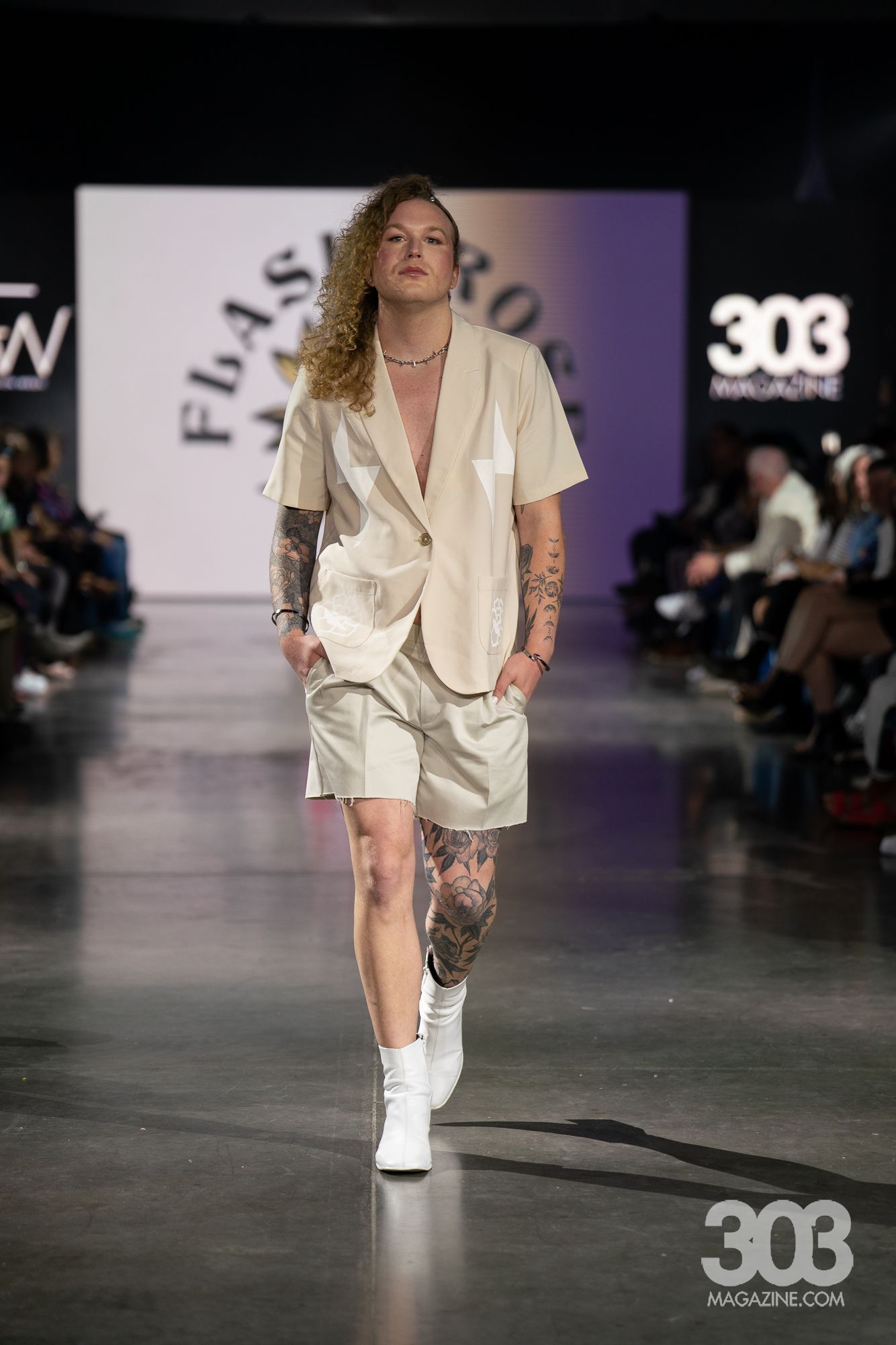 A model is walking down the runway at a fashion show.