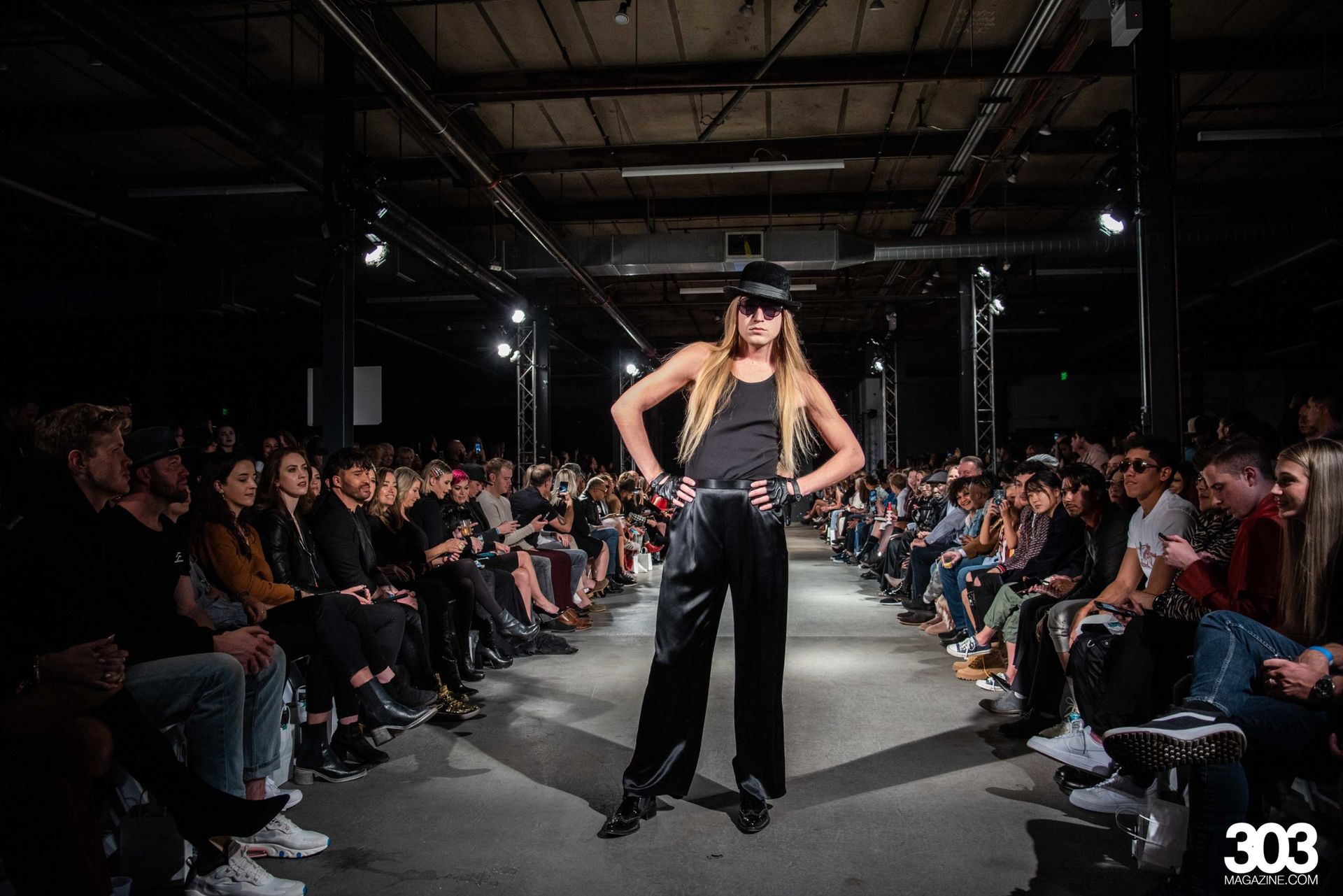 A woman is walking down a runway at a fashion show.