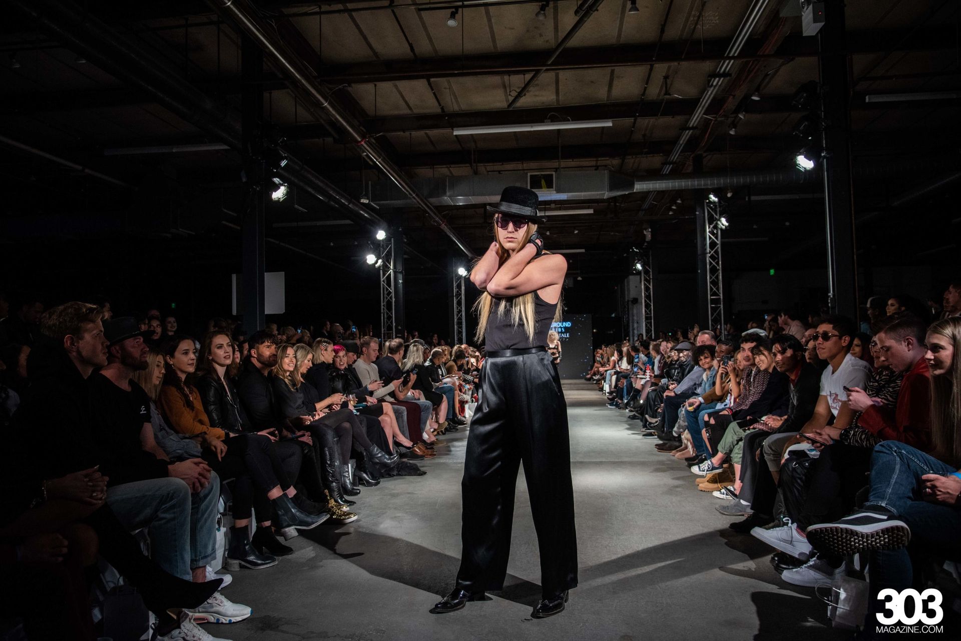 A woman is walking down a runway at a fashion show.