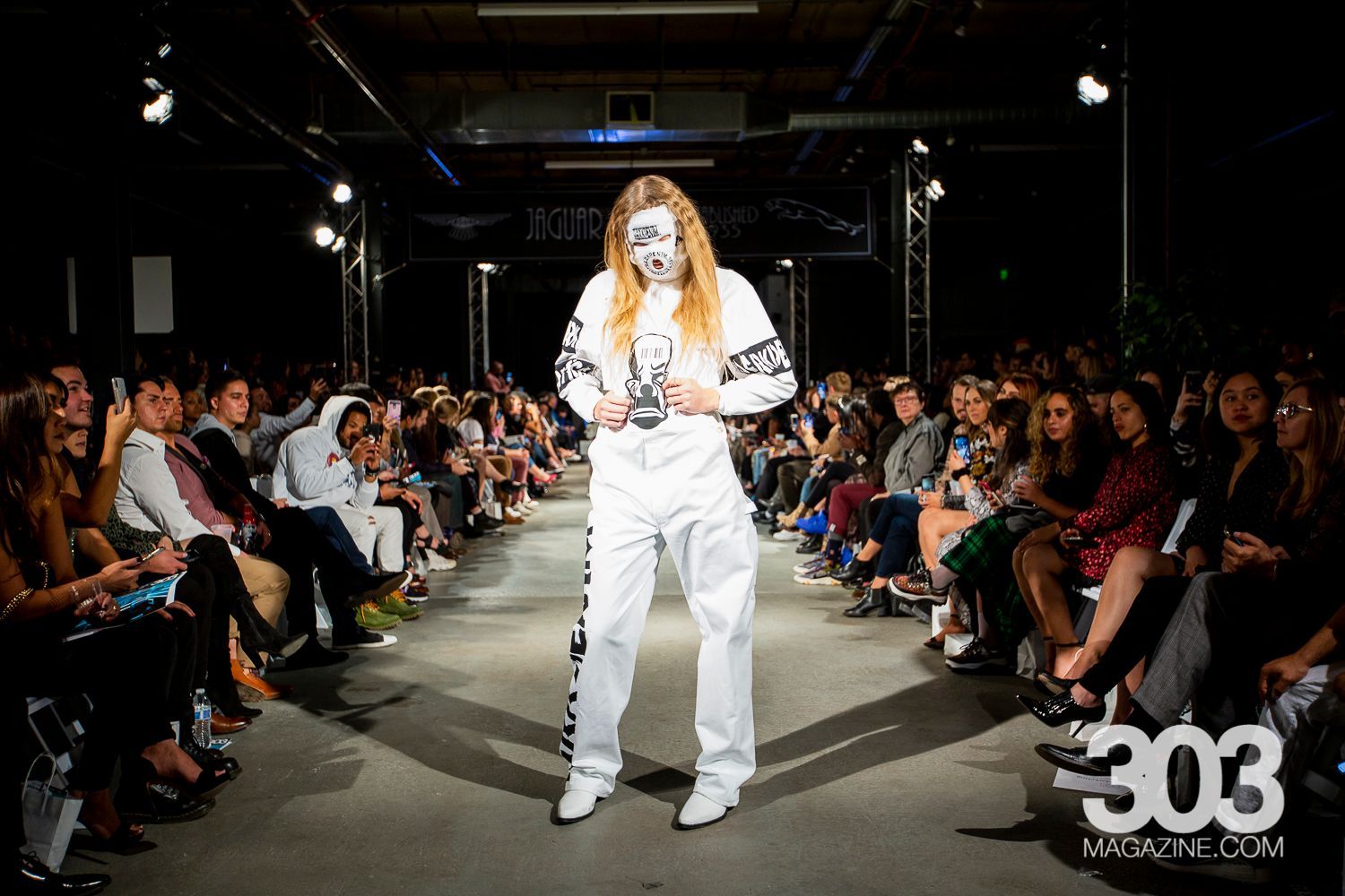 A model is walking down the runway at a fashion show.