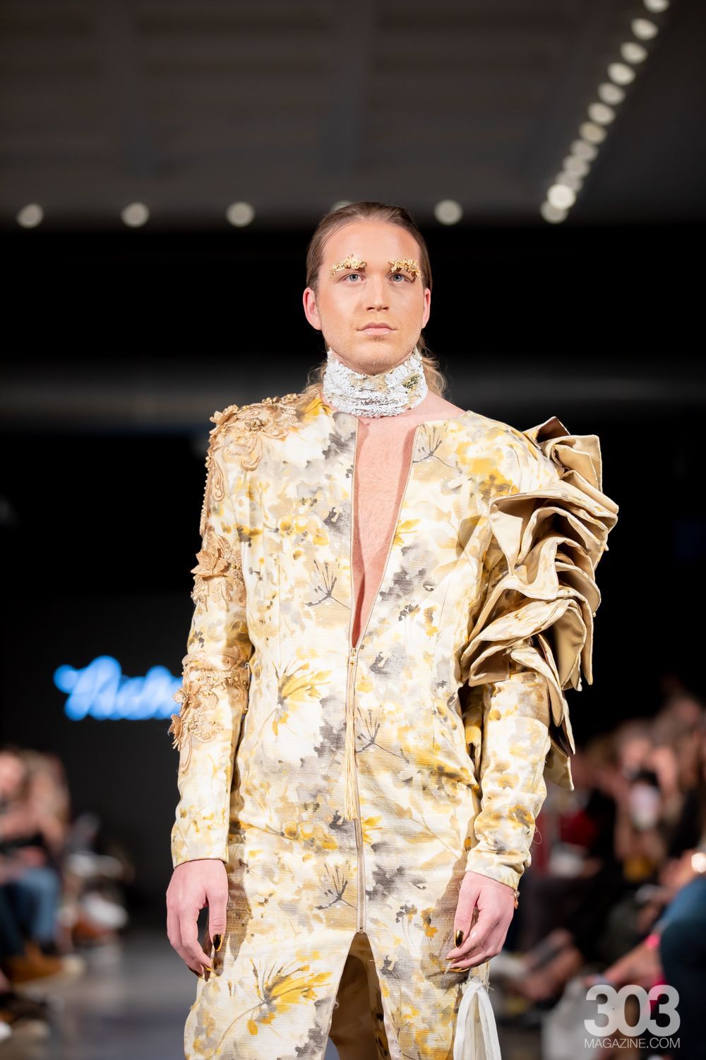 A model is walking down the runway at a fashion show.