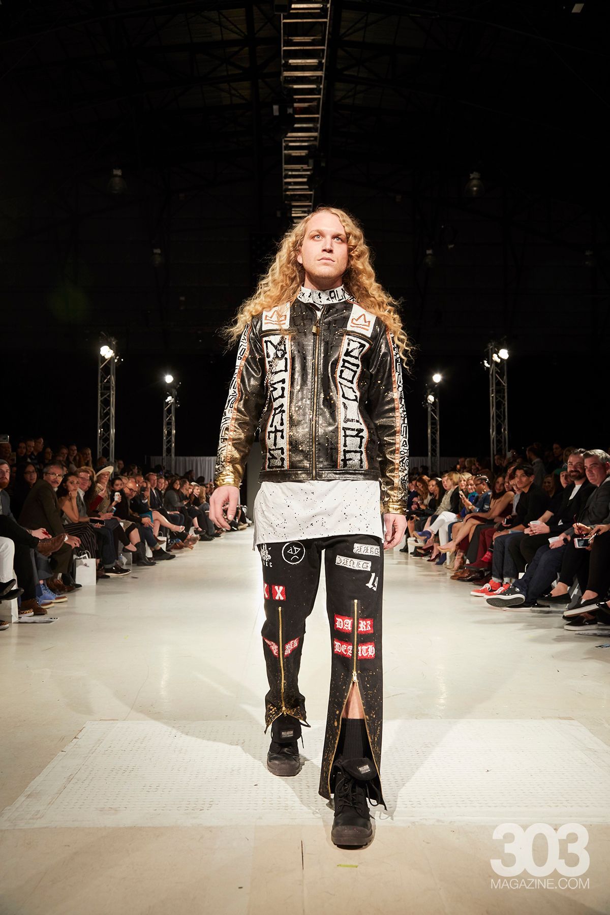 A model is walking down the runway at a fashion show.