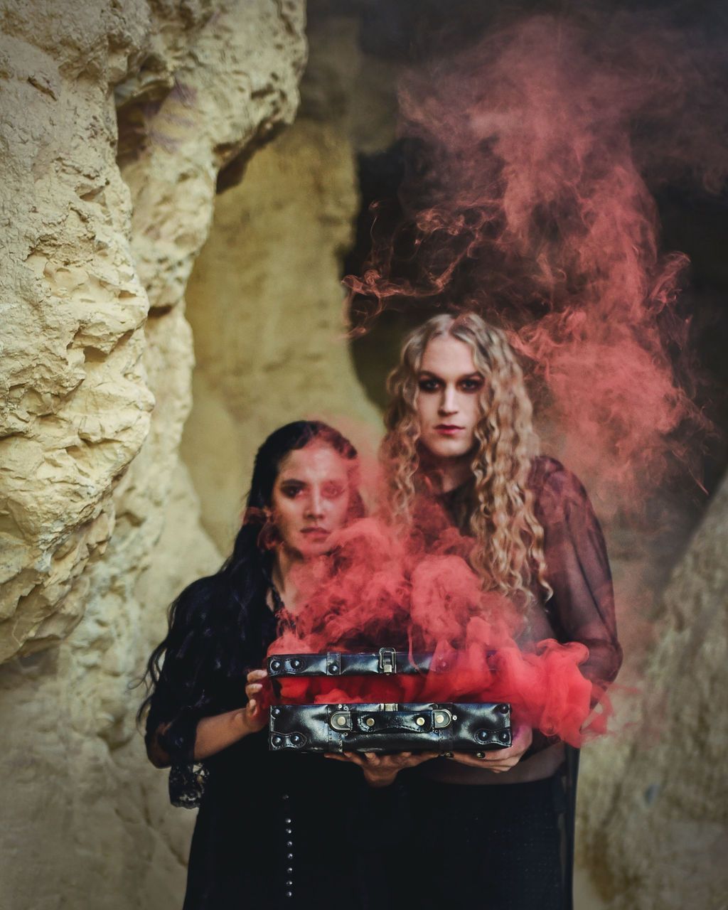 Scotty posing with a woman as they model for a halloween-themed photoshoot in a cave