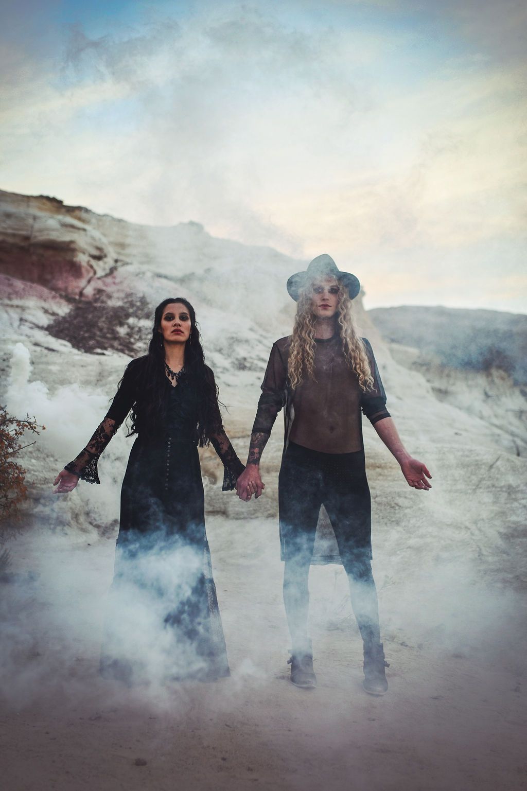 Scotty posing with a woman as they model for a halloween-themed photoshoot in a cave