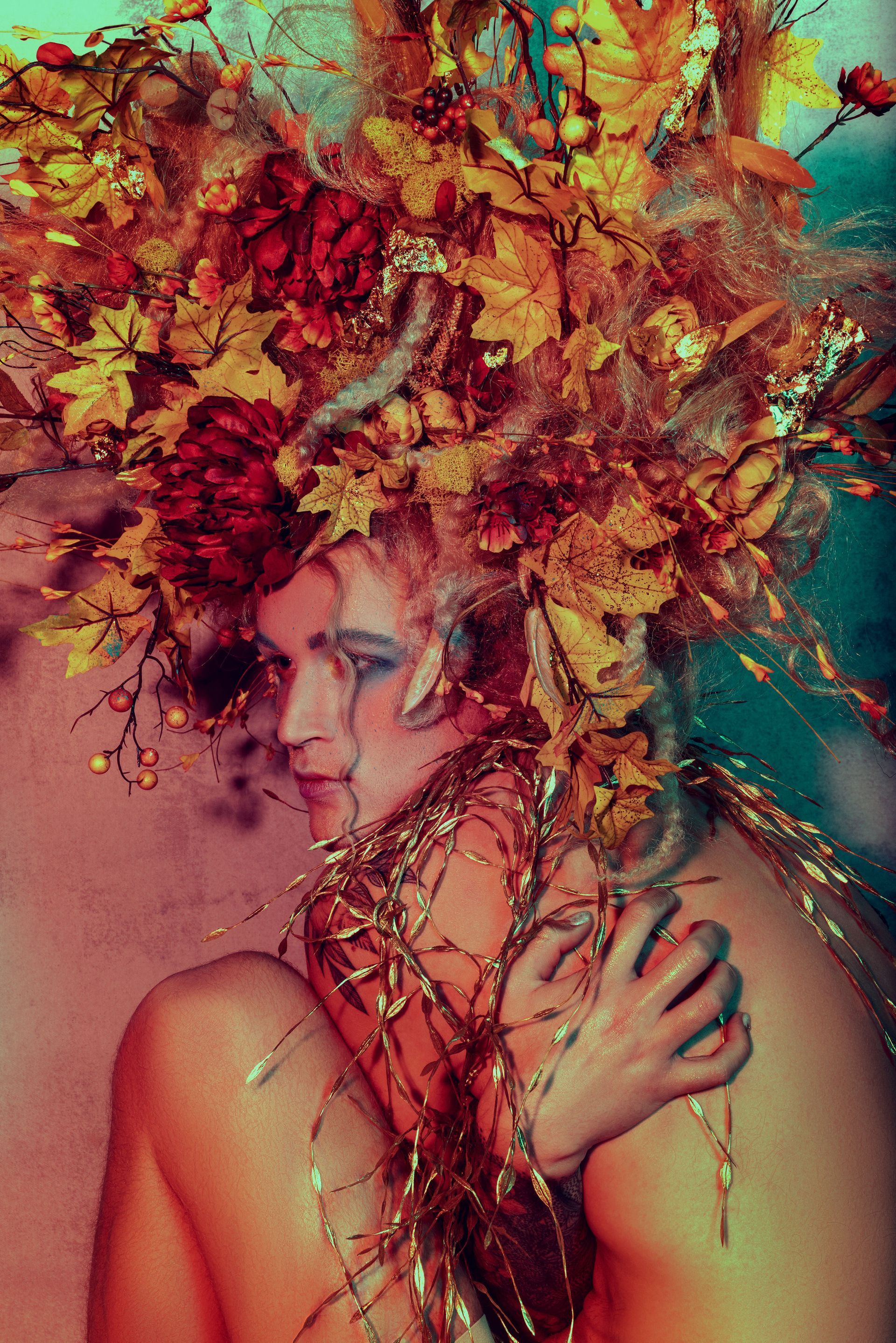 A woman is wearing a crown of flowers on her head for a fashion photo shoot.