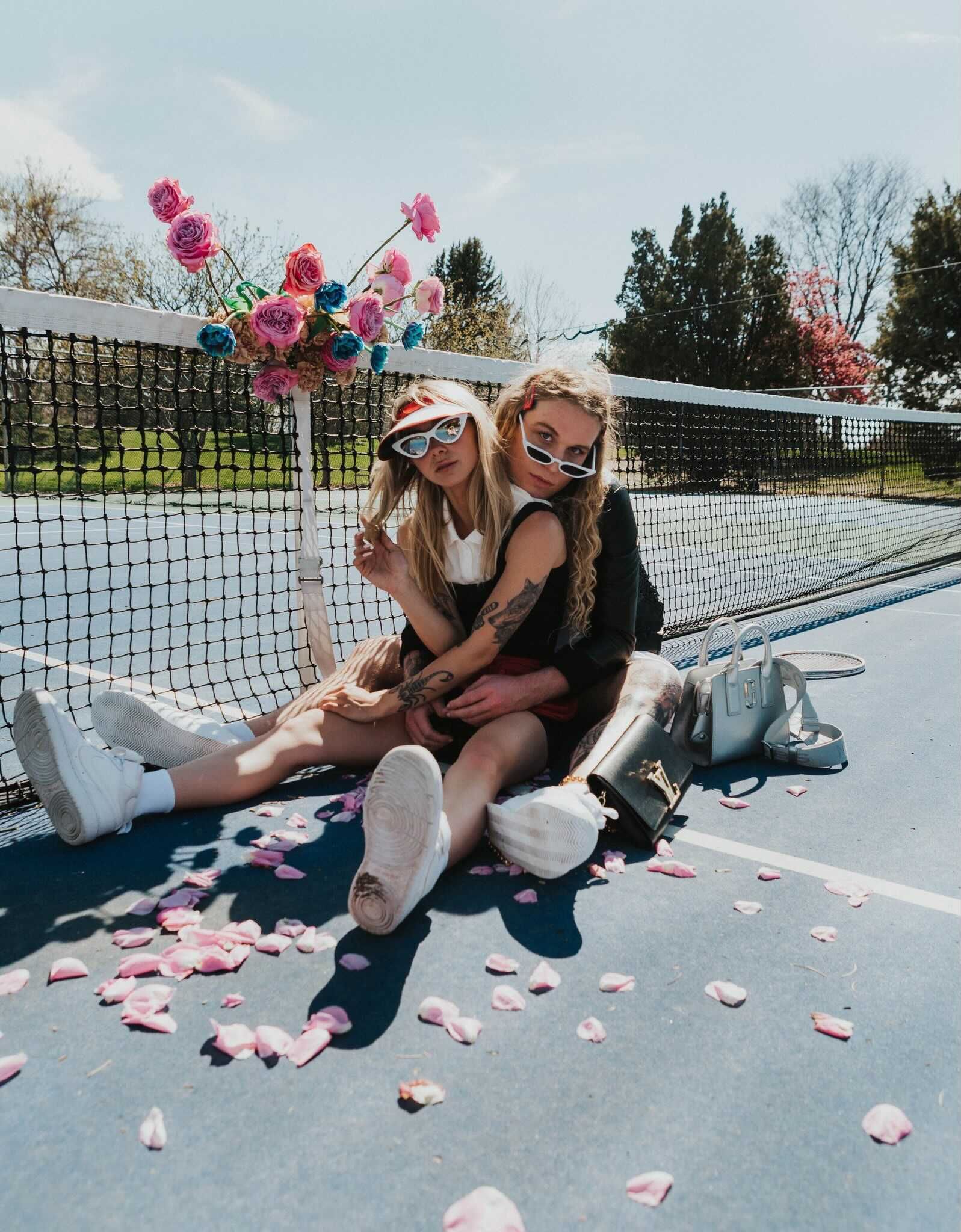 Scotty posing as a model on a tennis court with flowers for a photoshoot