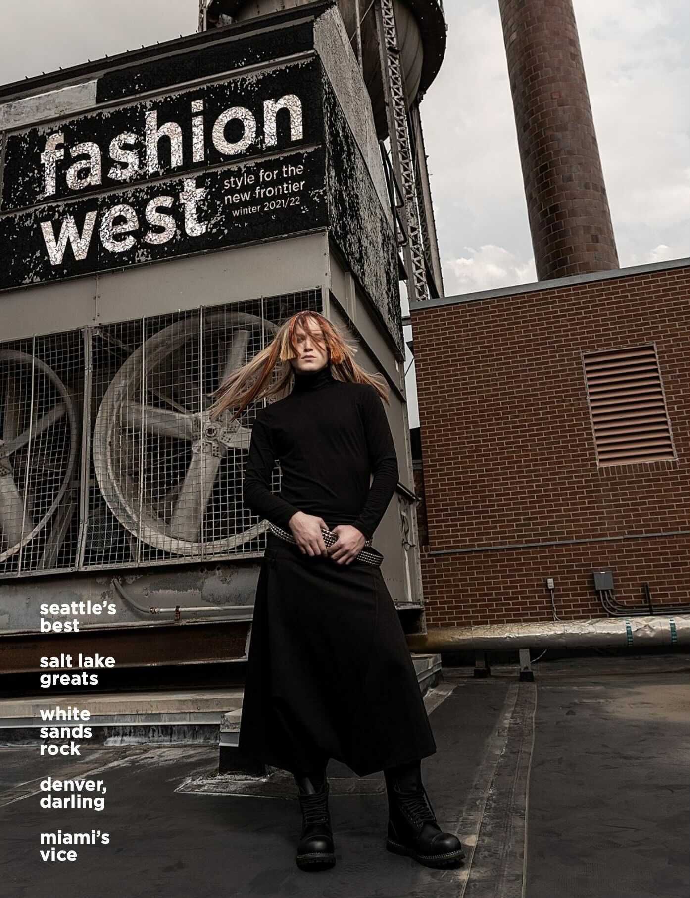 Scotty in a black dress is standing in front of a brick building for a fashion magazine.