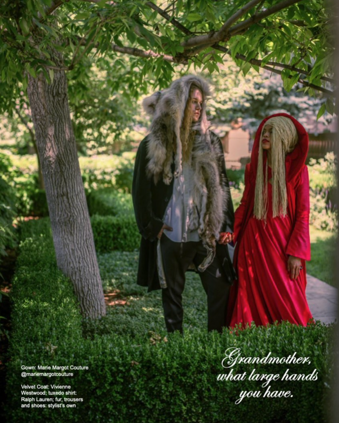 A woman in a red dress is standing next to a man in a wolf costume for a fashion magazine photo.