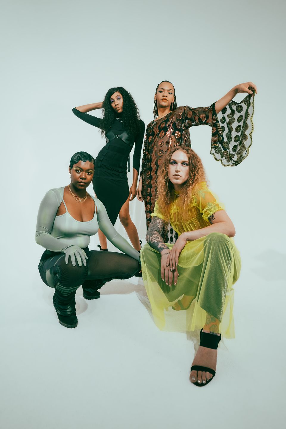 A group of women are posing for a picture together for a fashion photo shoot.