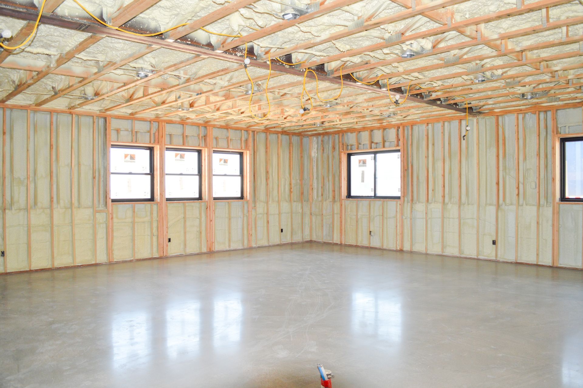 A large warehouse with a garage door and lots of tools in it