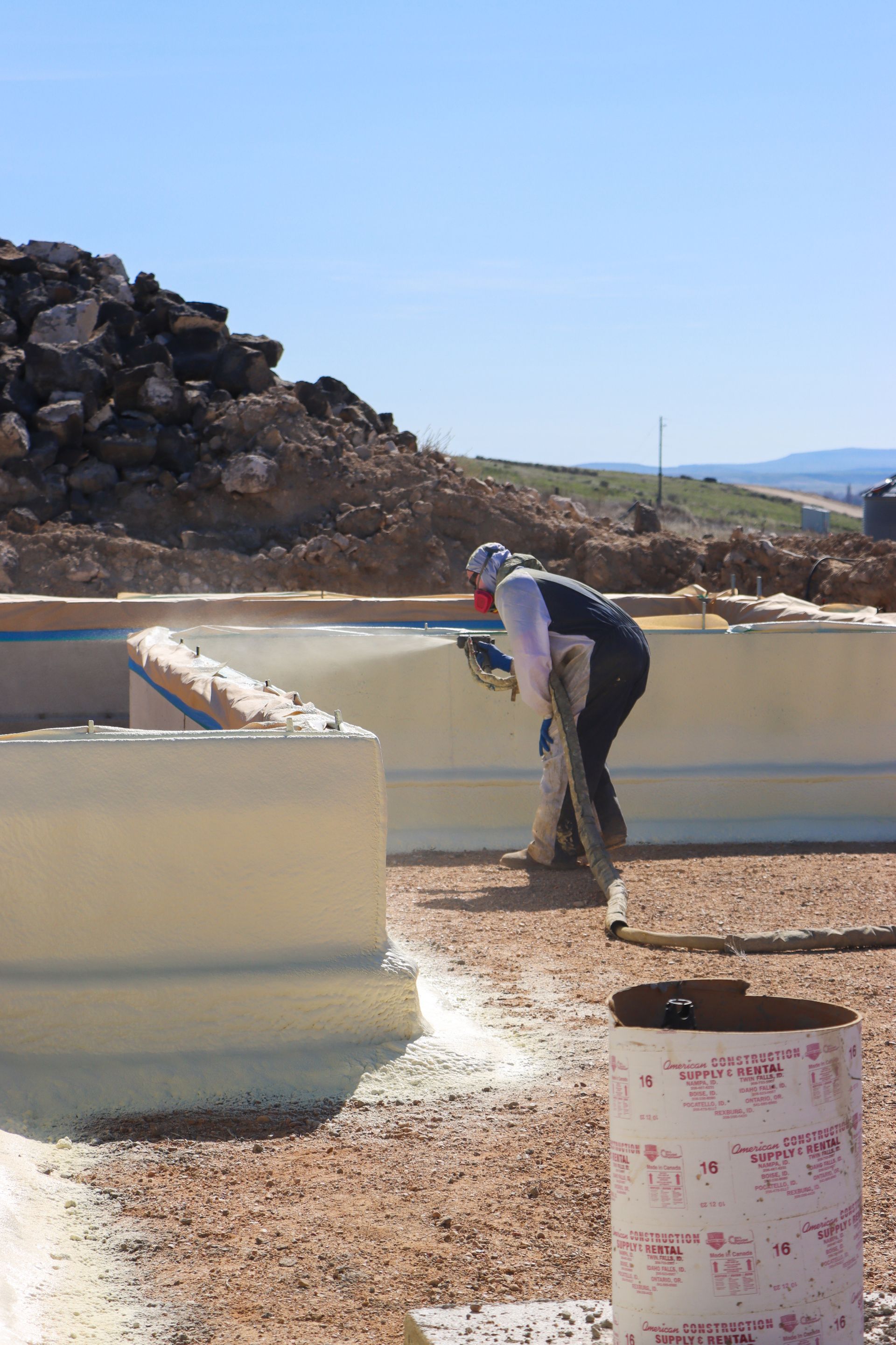 A man is spraying foam on a wall.