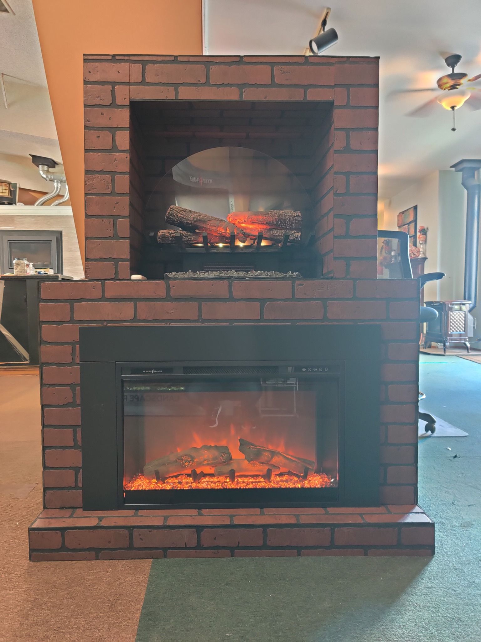 Brick fireplace with electric fire, flames visible in the inset and lower levels.