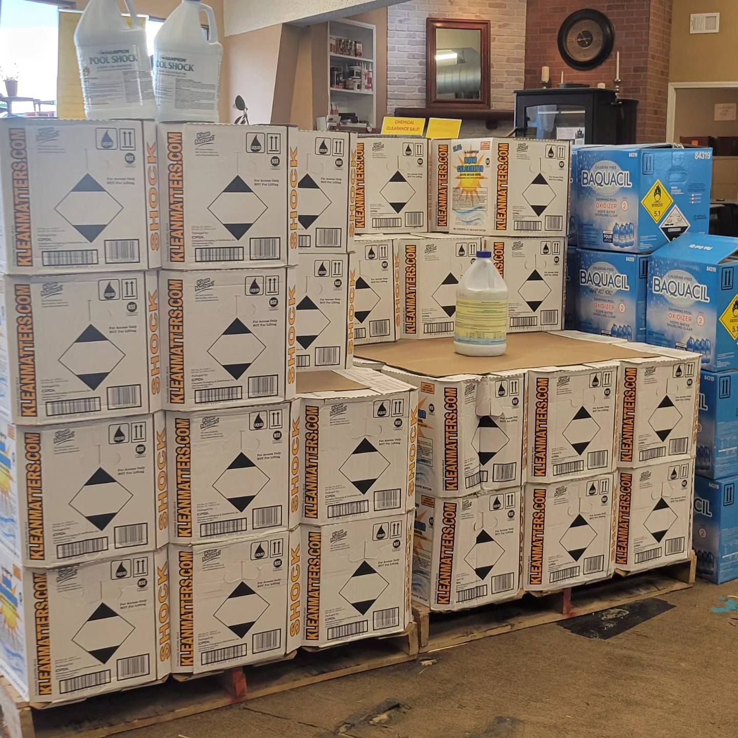 Boxes of cleaning supplies stacked on pallets in a store.