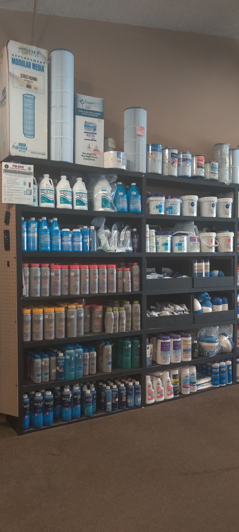 Shelves stocked with cleaning supplies and pool chemicals in a store.