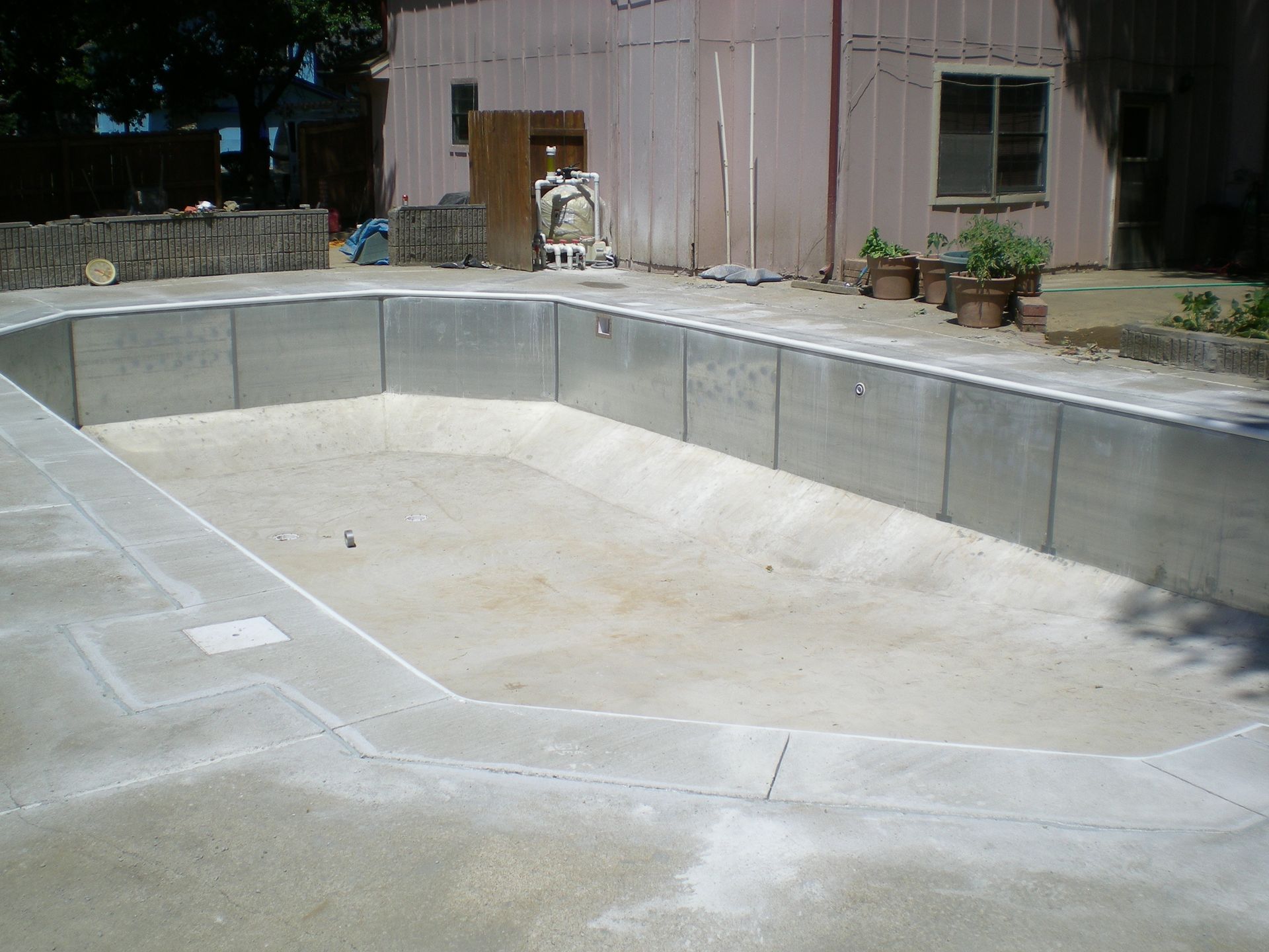 Empty concrete swimming pool under construction, viewed from the side.