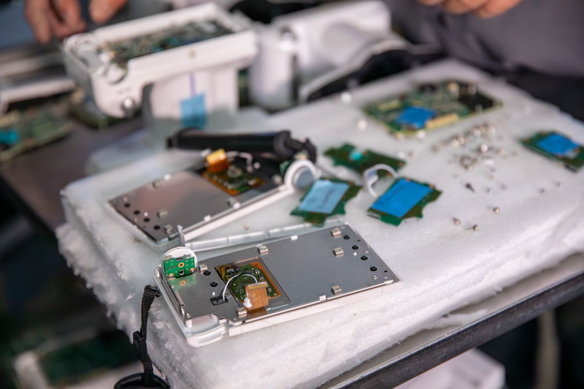 Person fixing circuit board inside metal machine.