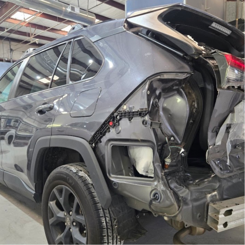 Damaged gray Toyota RAV4, rear quarter panel open, showing internal frame, in a repair shop | Axe-A-Dent Auto Collision