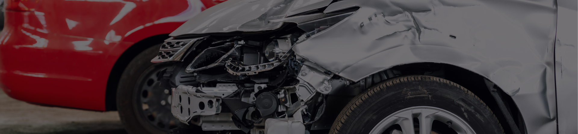 Person in overalls spraying a tire with a paint gun in a body shop | Axe-A-Dent Auto Collision