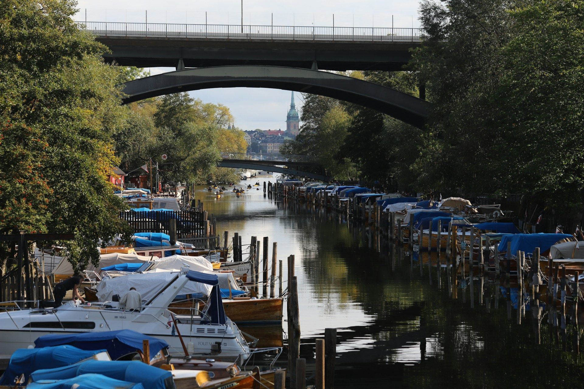 The narrow canal along Långholmen in Stockholm lined with moored boats.