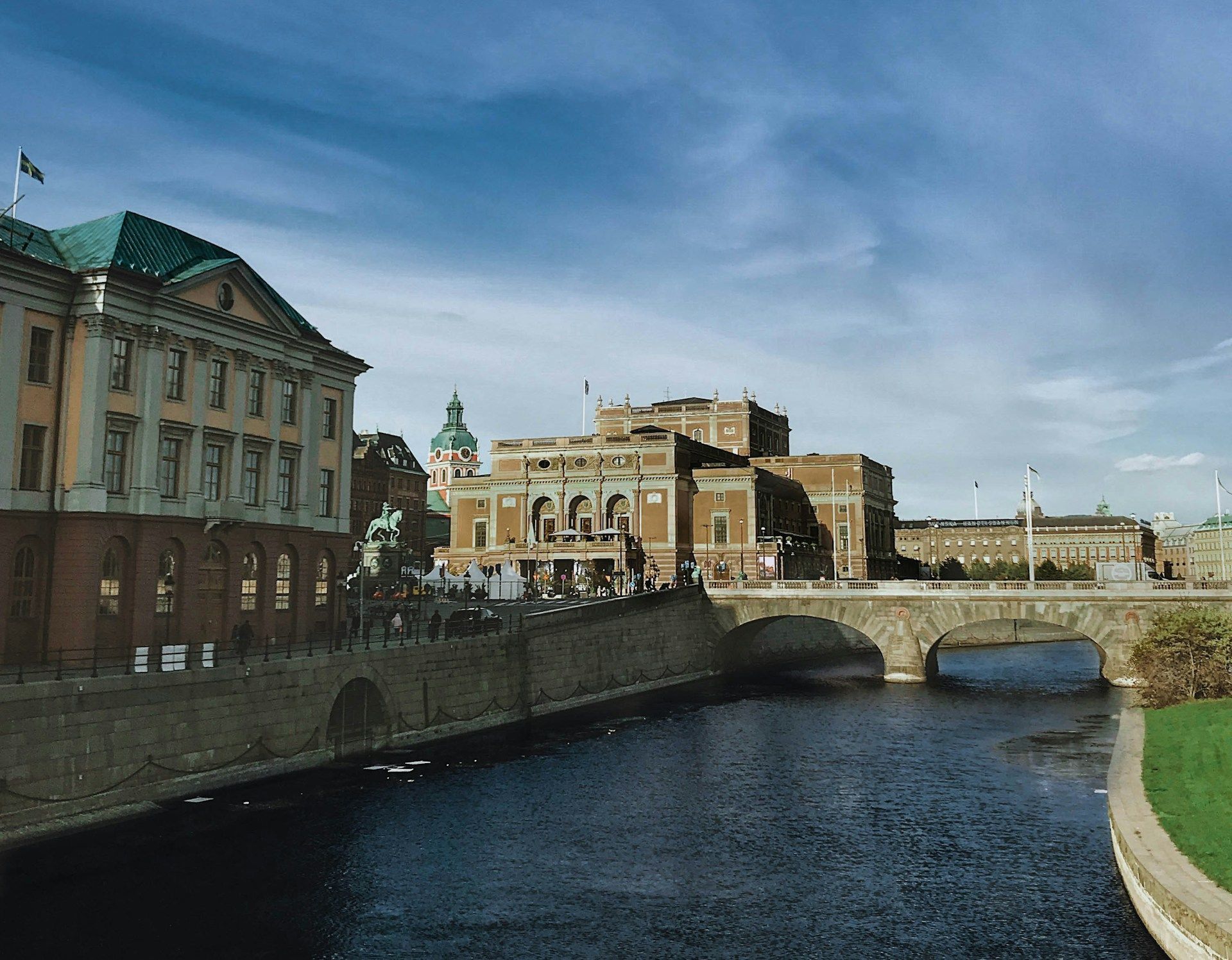 The Royal Swedish Opera house and neighboring buildings stand along the water in Stockholm