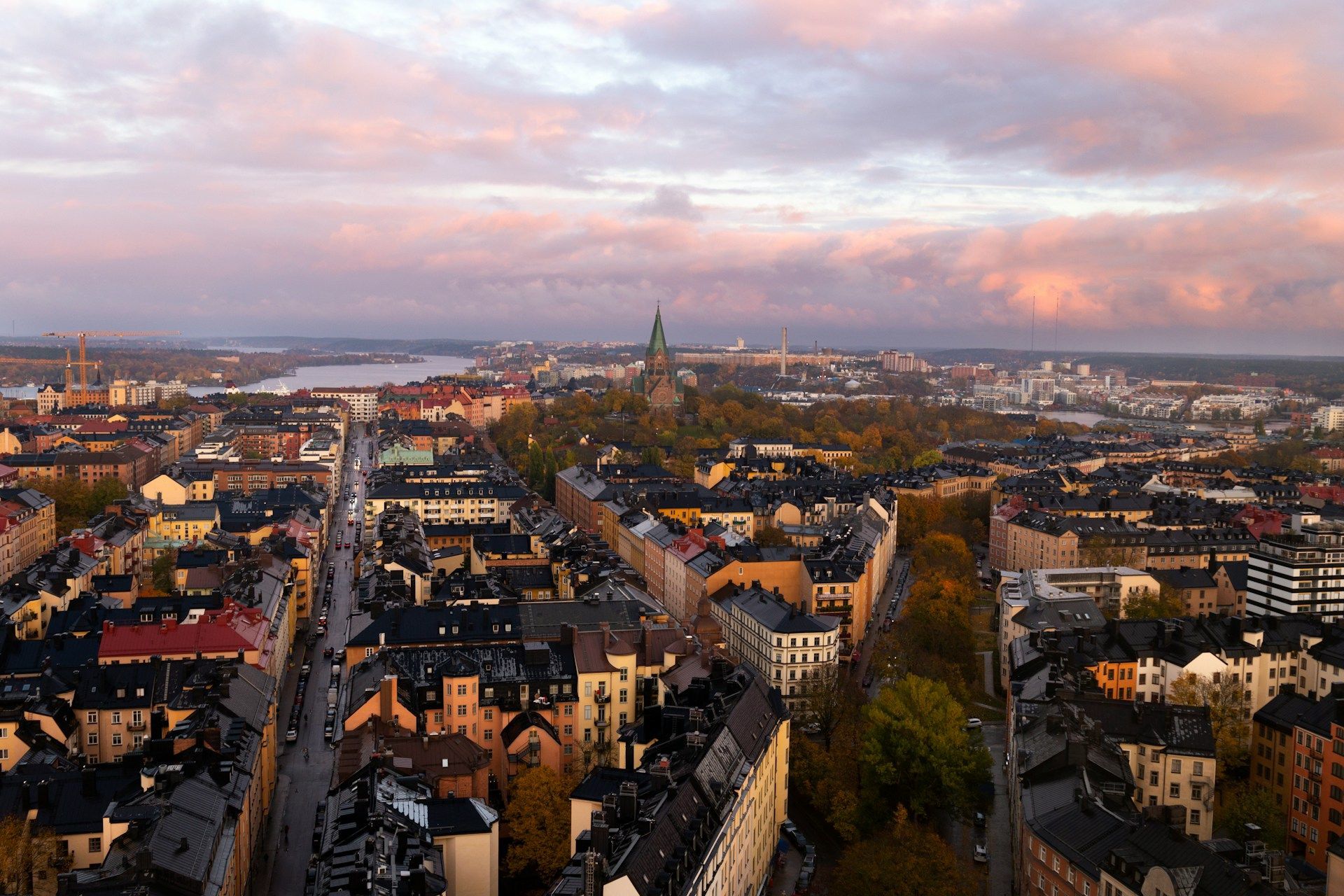 An aerial view of Stockholm, Sweden, featuring dense city blocks under a soft sunset sky.