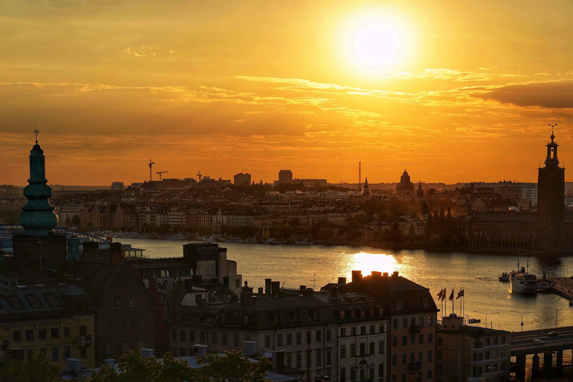 Golden sunset over the Stockholm skyline, featuring City Hall and historic buildings along the water.