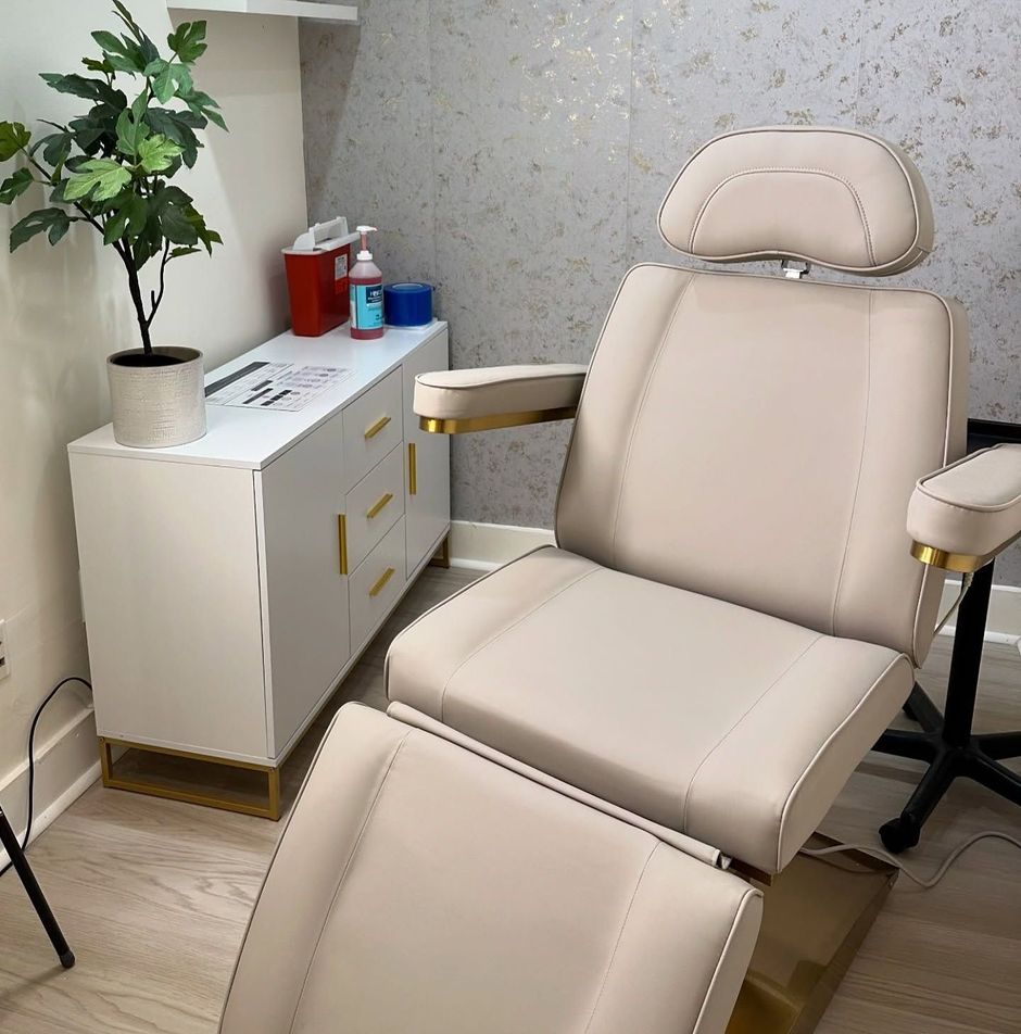A white chair is sitting in a room next to a plant.