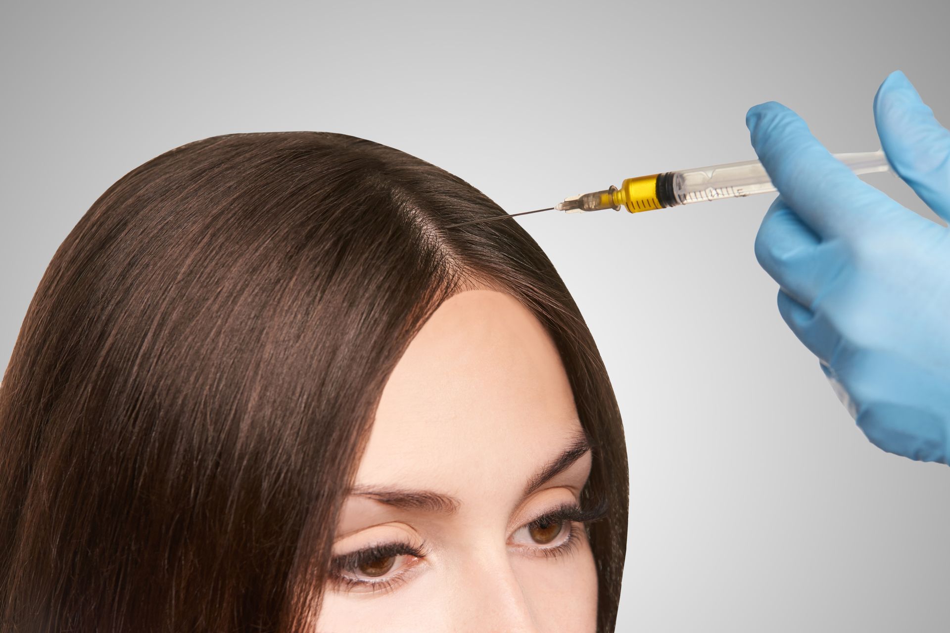 A woman is getting an injection in her hair.