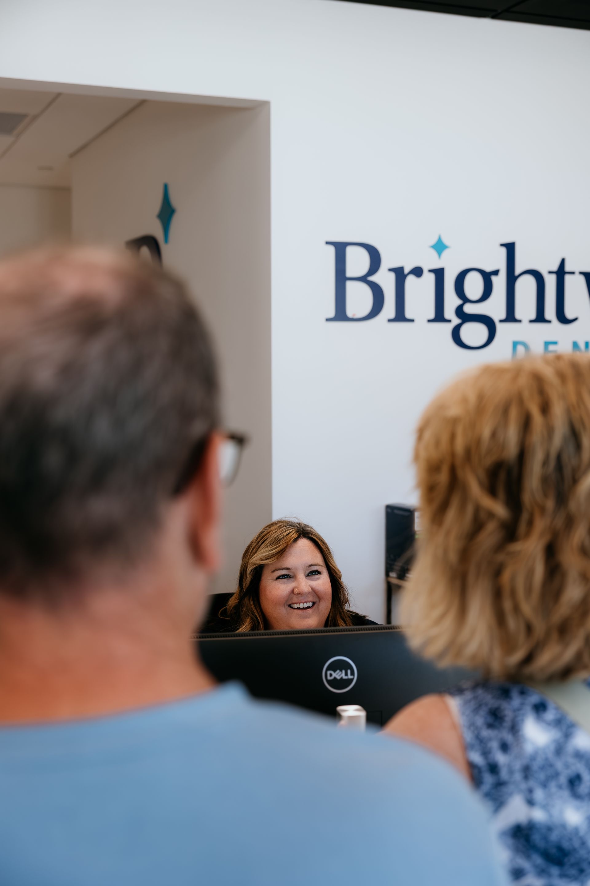 A young boy in a yellow turtleneck is laughing with his mouth open.