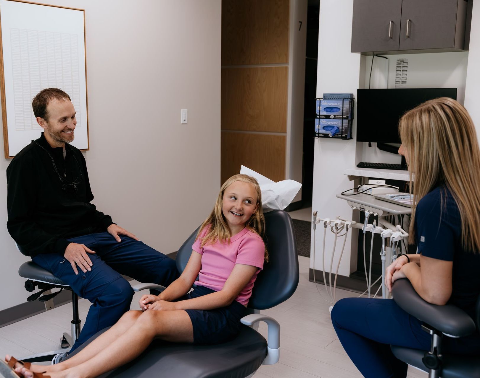 A woman is sitting on a couch holding a cell phone.