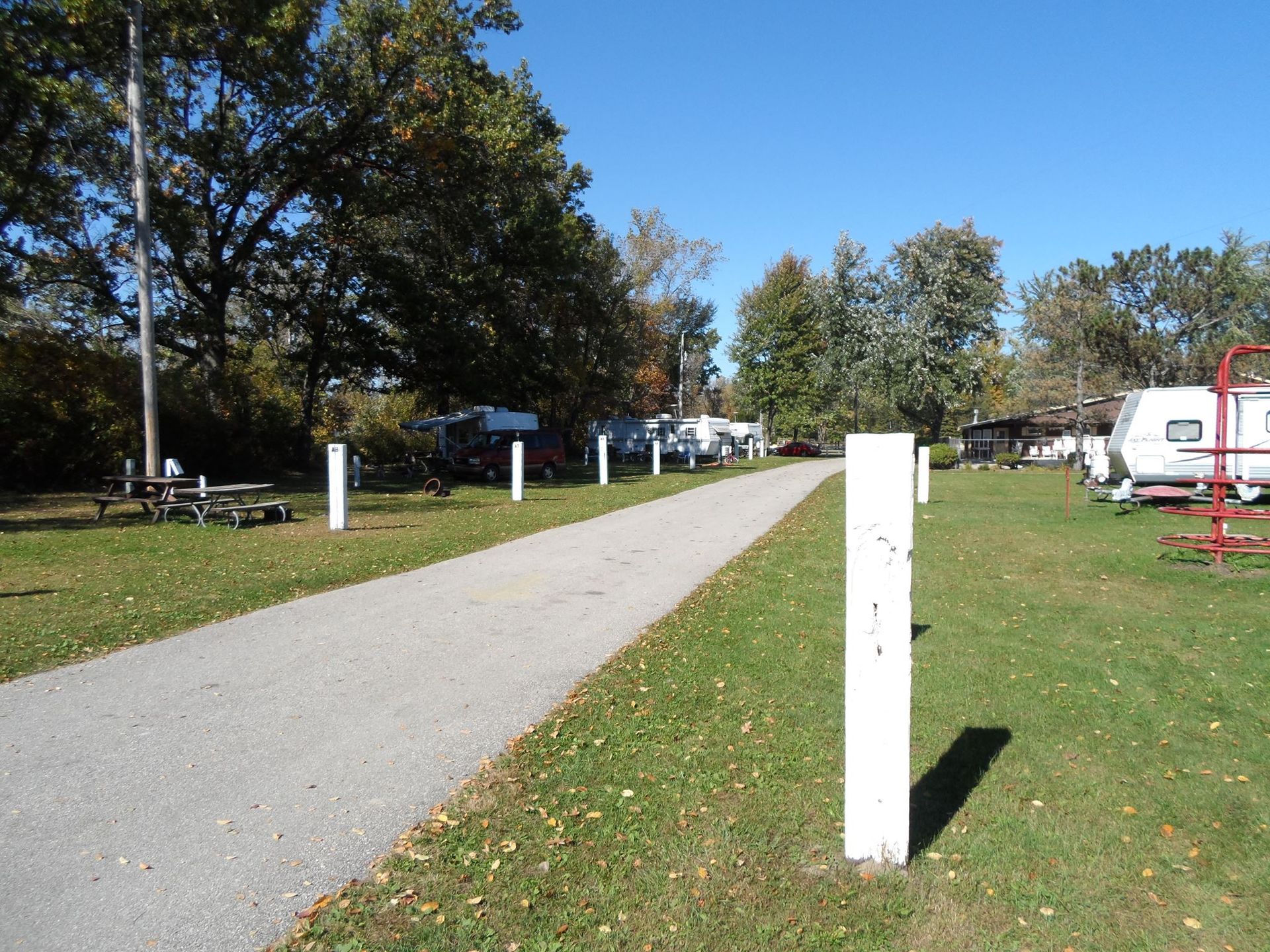 A path going through a park with a white pole in the middle