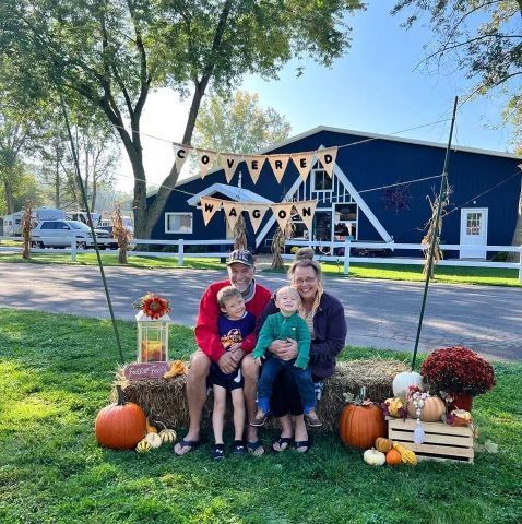 A family is posing for a picture in front of a blue building.