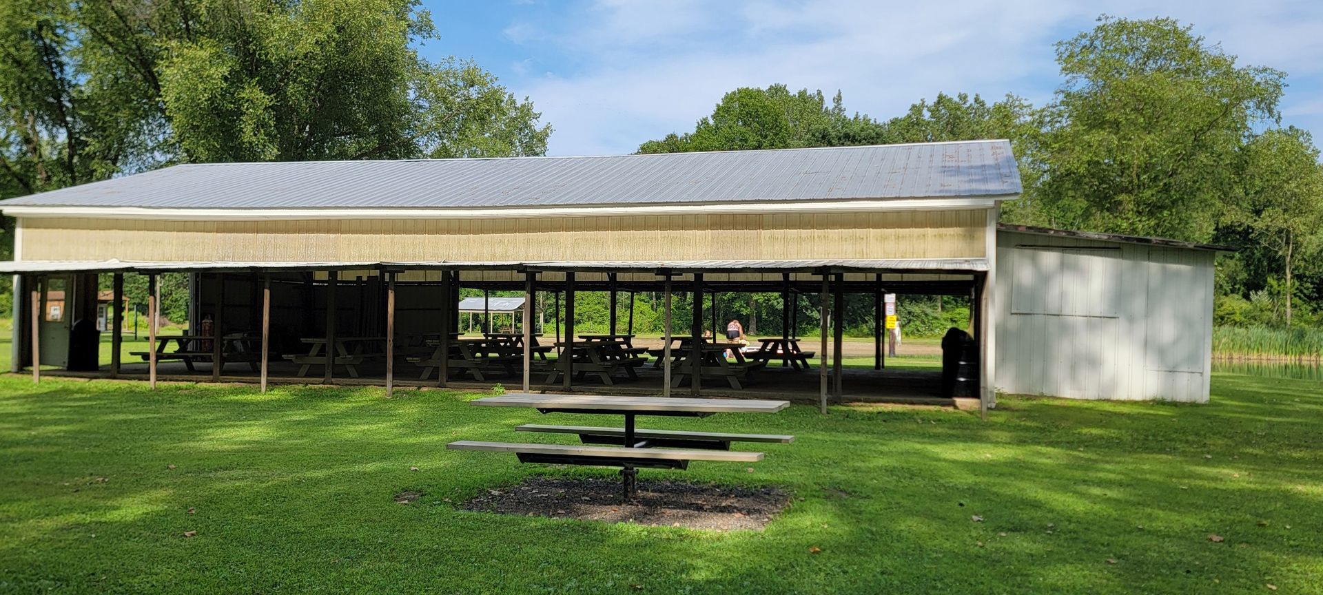A large white building with a picnic table in front of it.