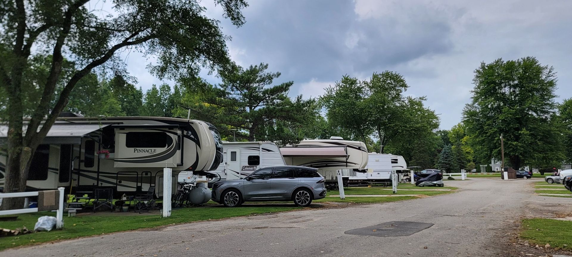A row of rvs parked on the side of a dirt road.