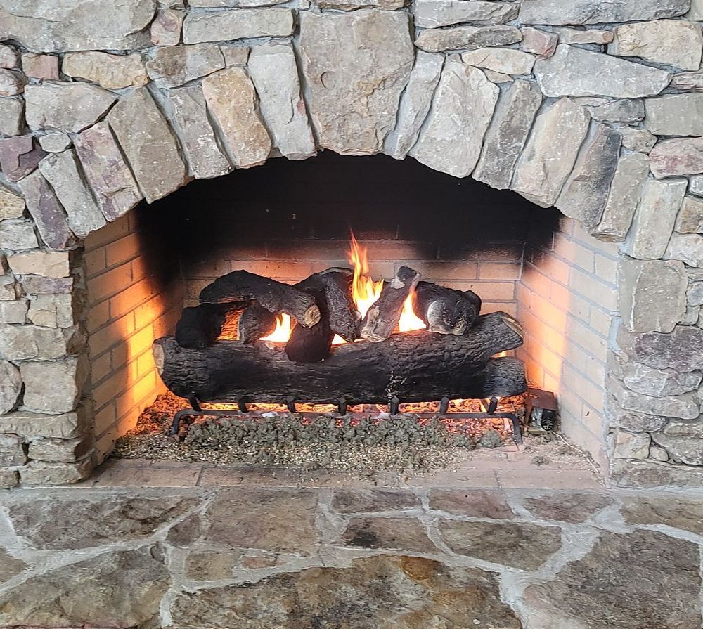 a fireplace with logs in it and a stone archway