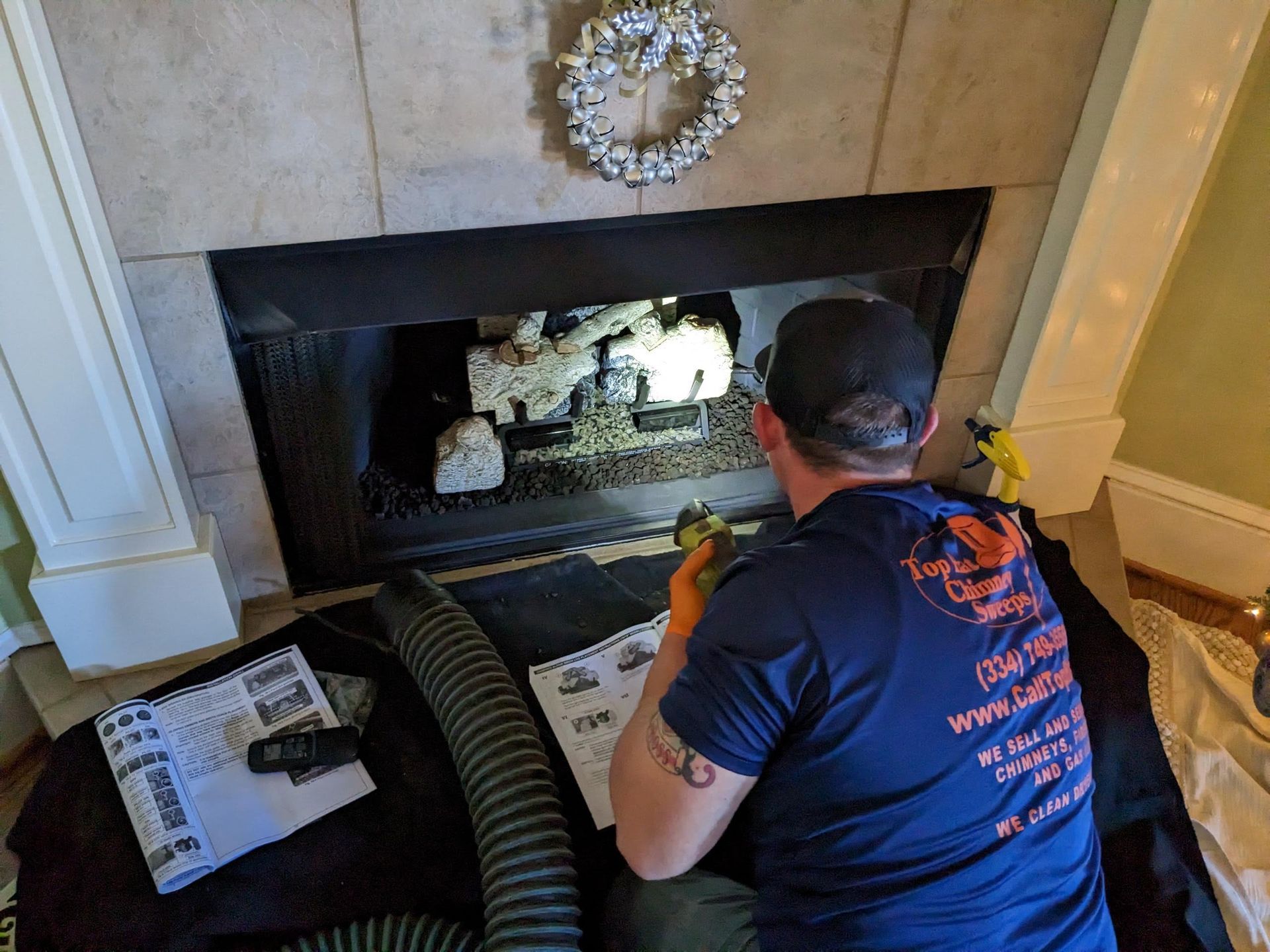 Top Hat Chimney Sweeps technician servicing a gas fireplace or gas logs