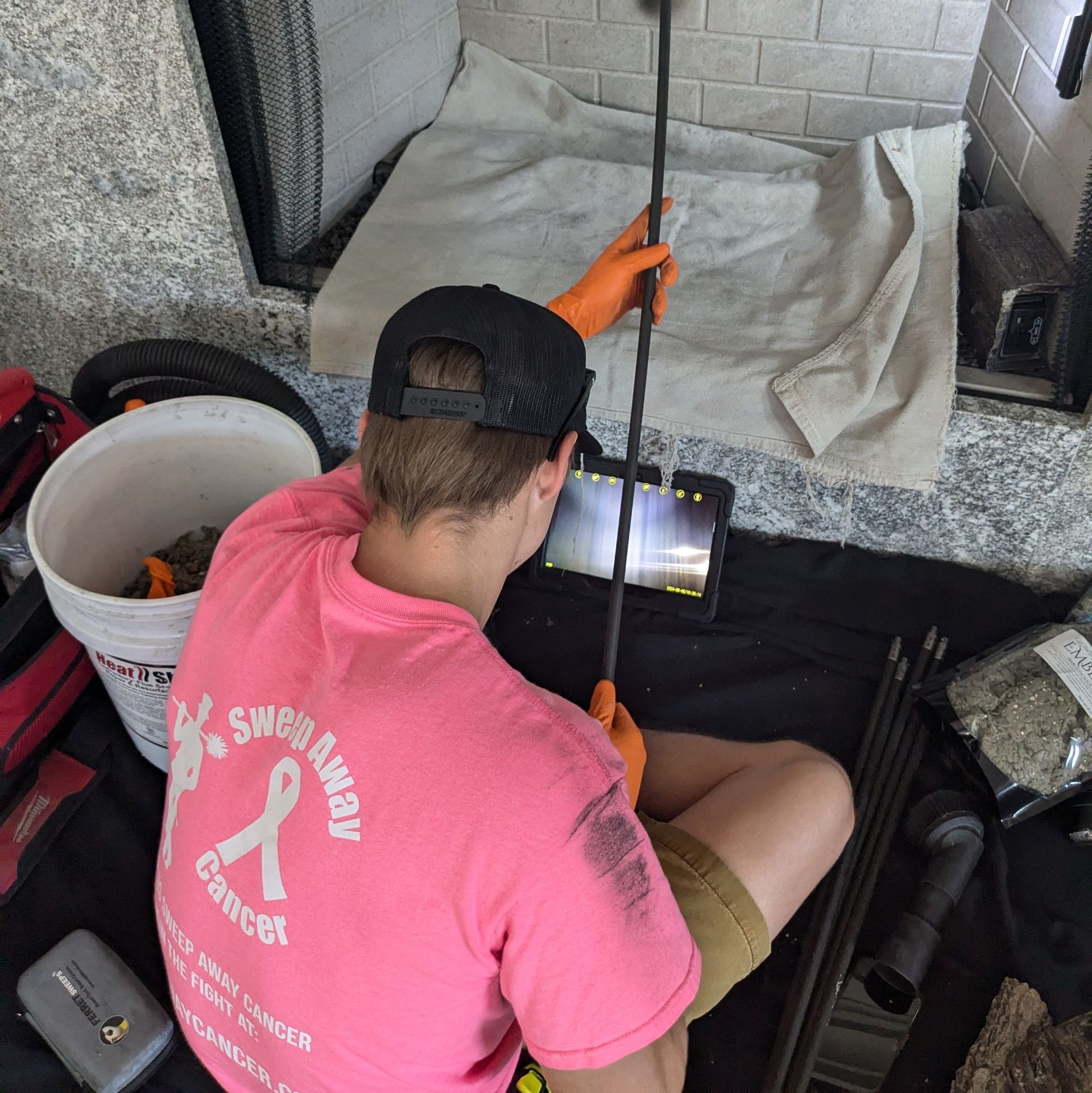 Top Hat Chimney Sweeps picture of a Certified Technician performing a video scan of a chimney