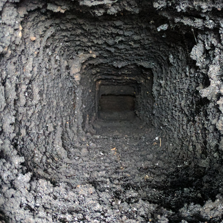 the inside of a very dirty chimney with a hole in the middle .