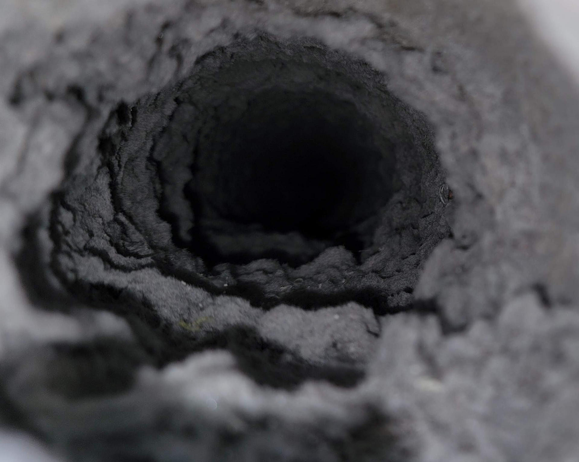 a close up of a dirty dryer vent with a hole in it .
