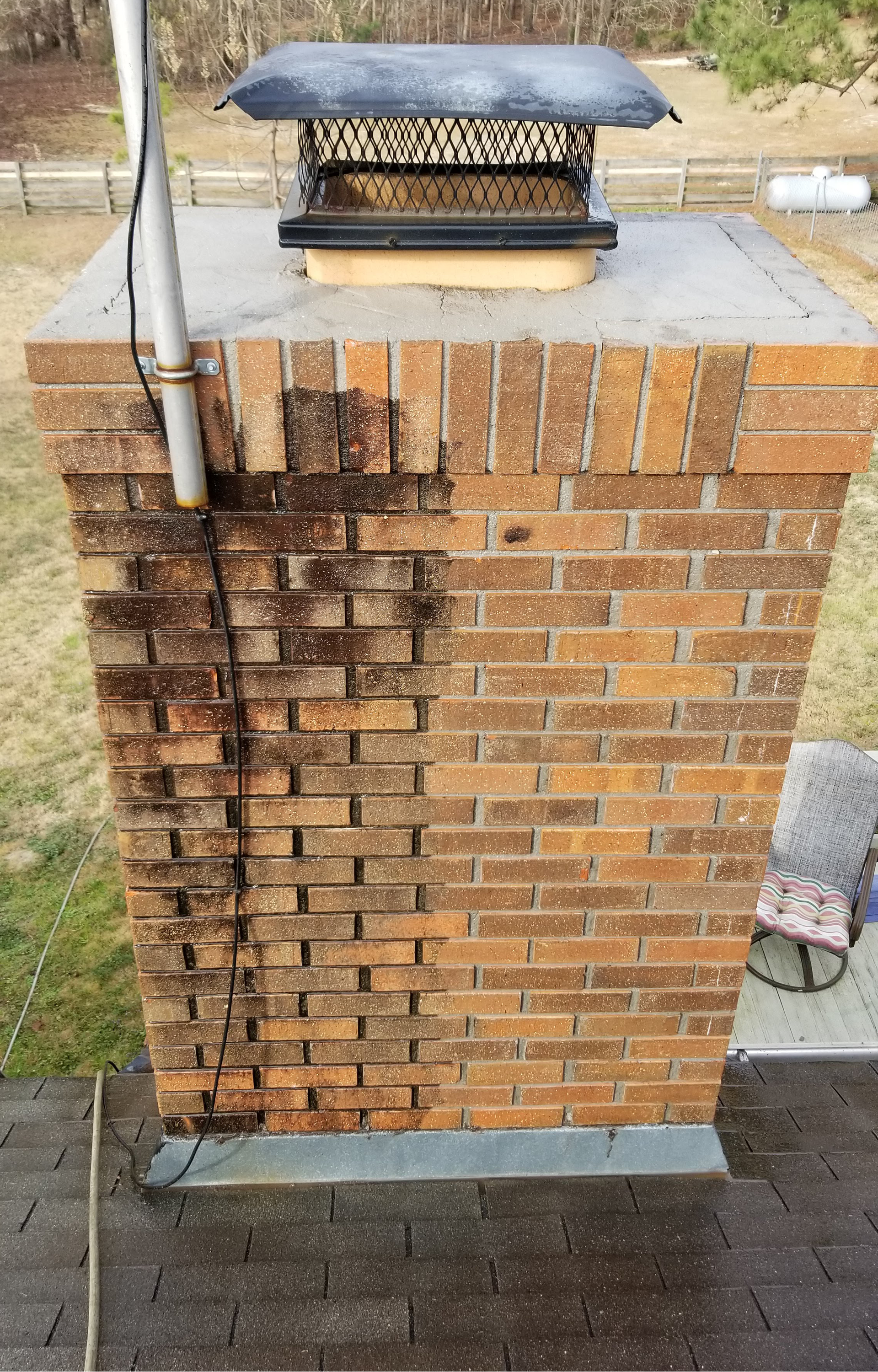 a brick chimney is sitting on top of a roof .