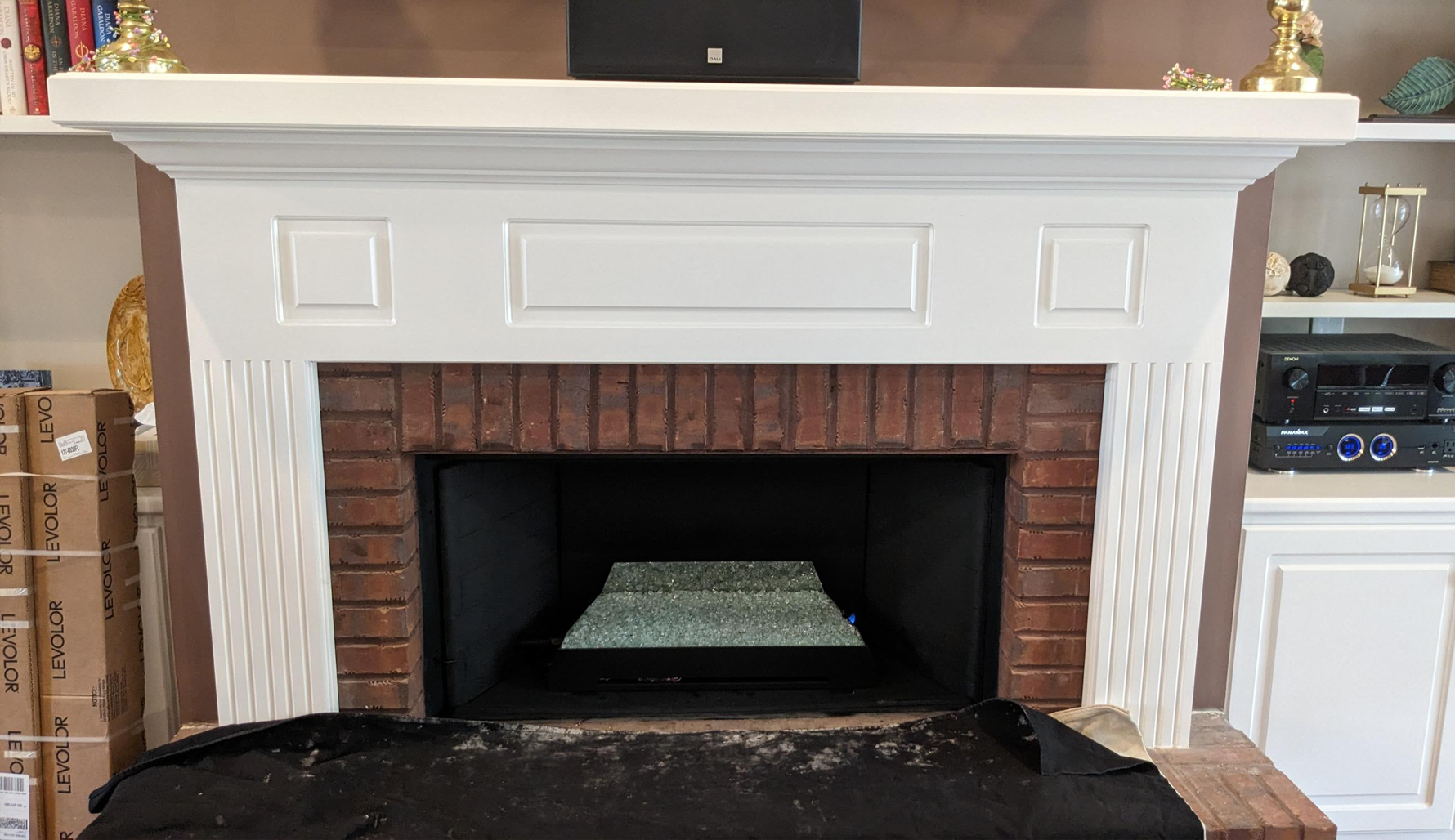 a fireplace with a white mantle and a brick mantle in a living room .