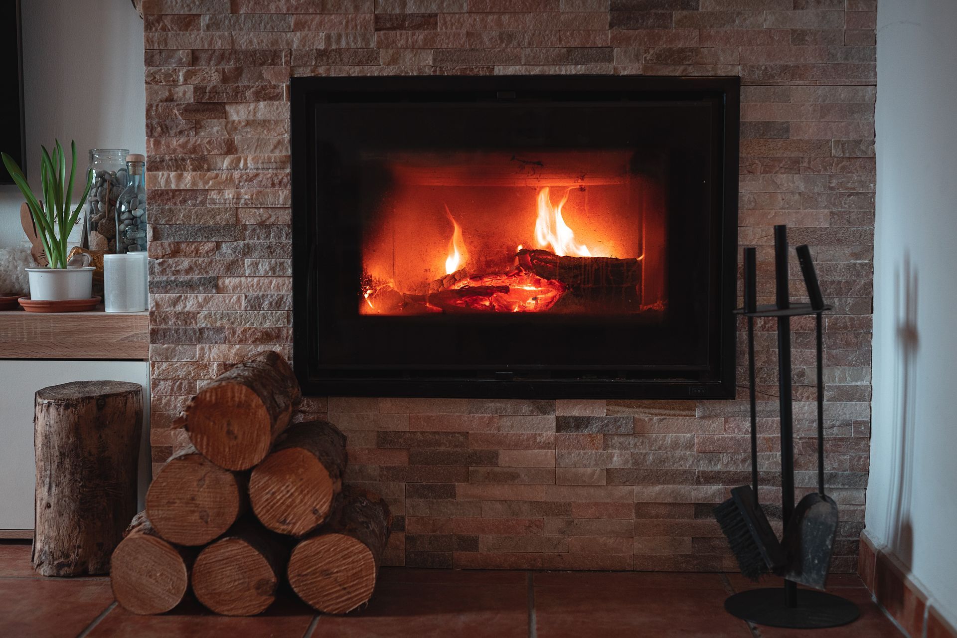 a fireplace with a pile of logs in front of it .