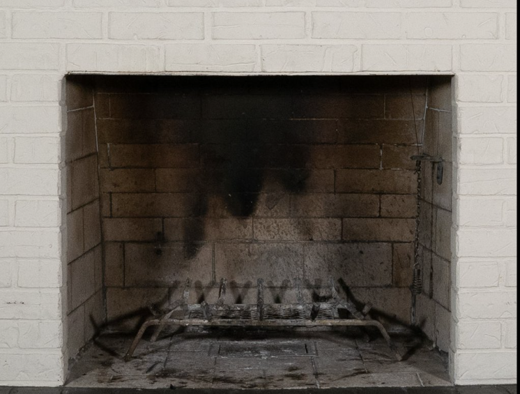 a fireplace with a stone surround and a white mantle
