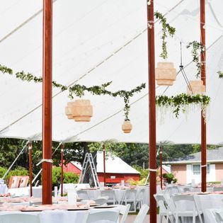 A large tent with tables and chairs underneath it.