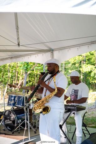 A man is playing a saxophone and a man is playing a keyboard.