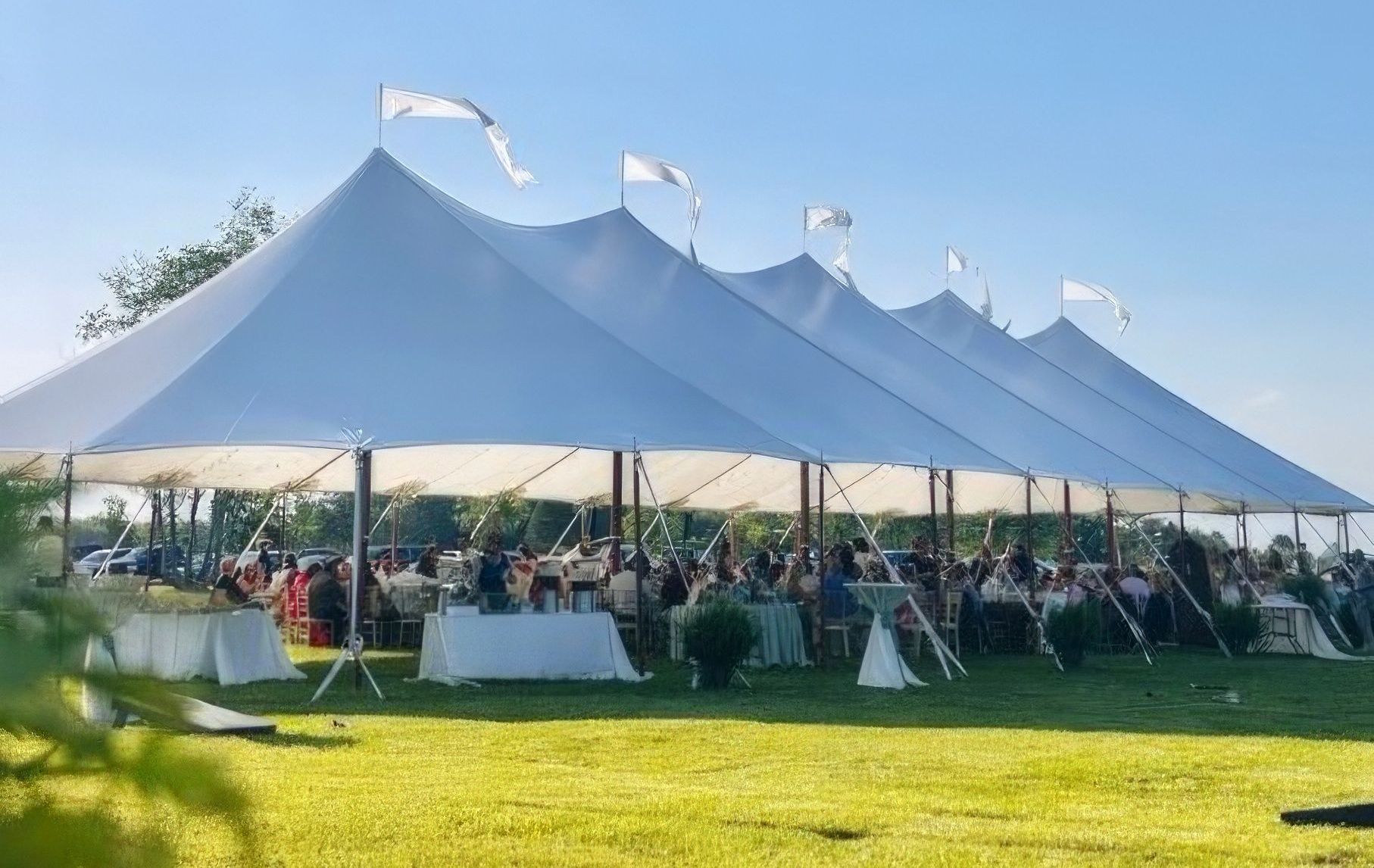 A large white tent with tables and chairs underneath it