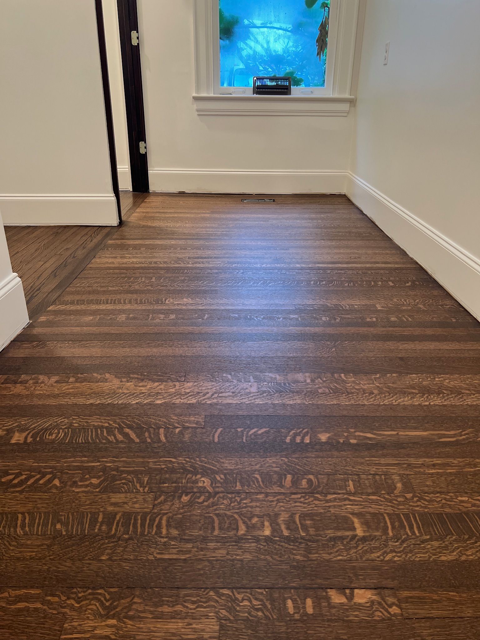 A room with a wooden floor and a window.