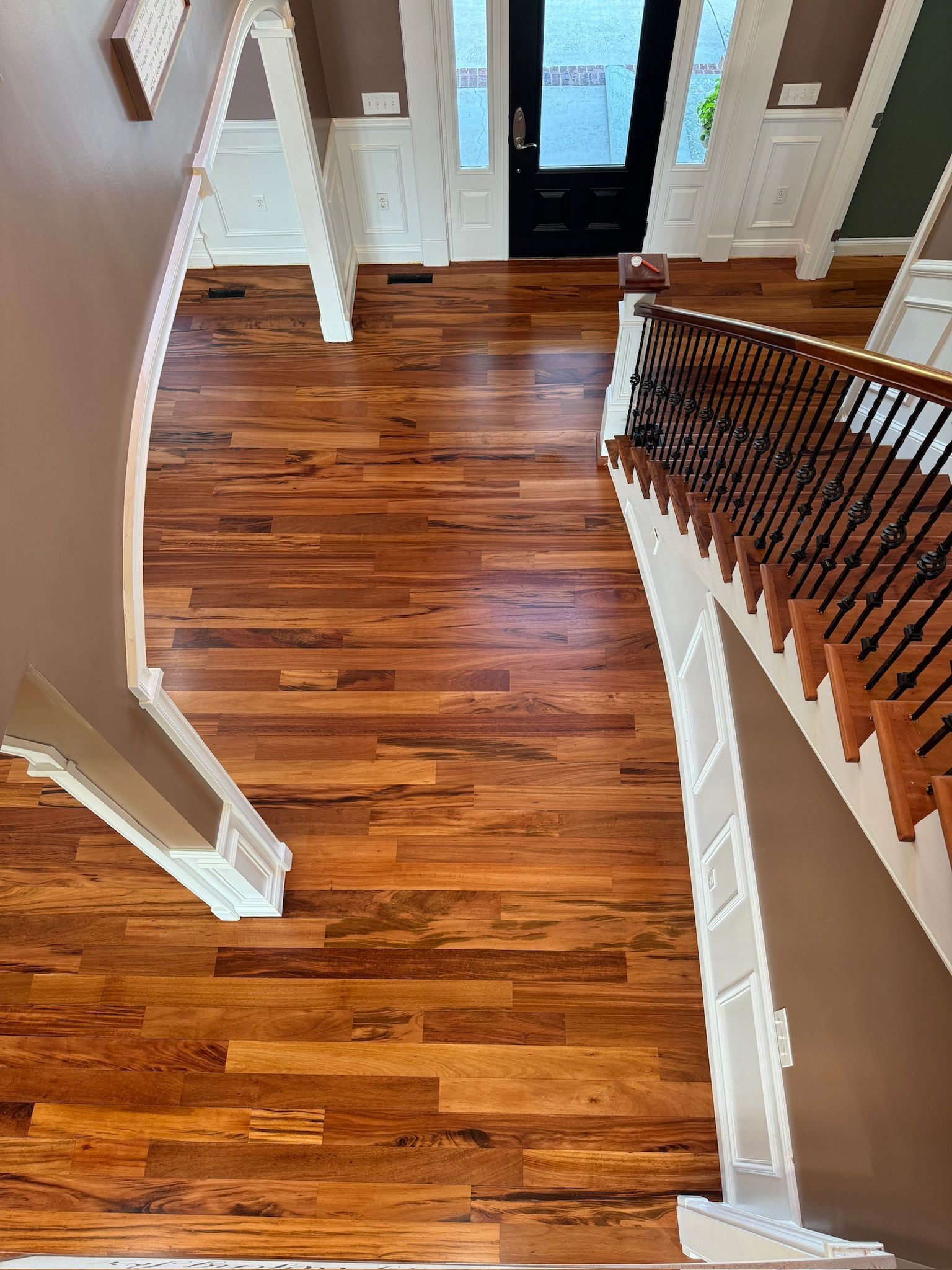 An aerial view of a hallway with hardwood floors and stairs