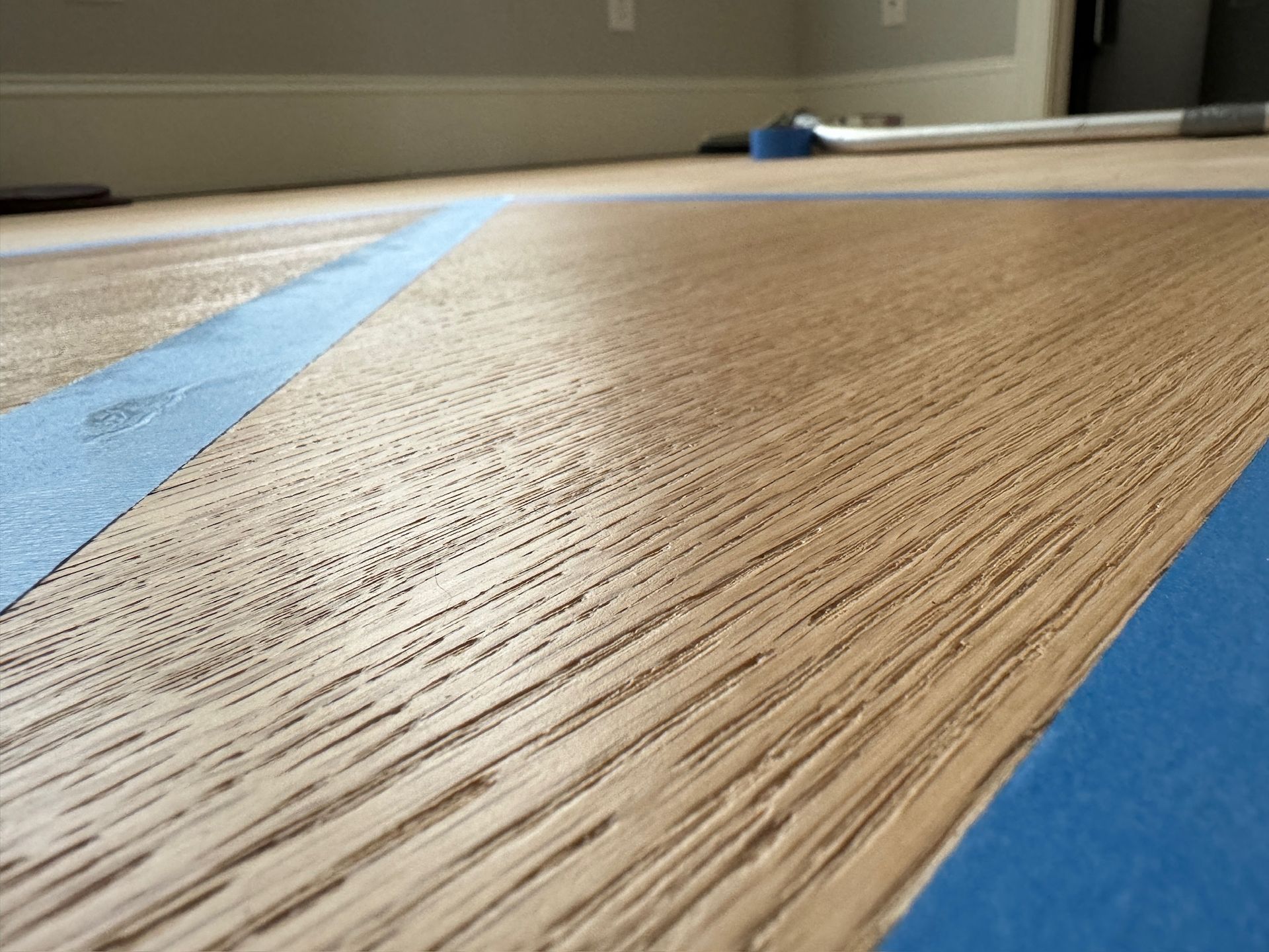A close up of a wooden table with blue tape on it