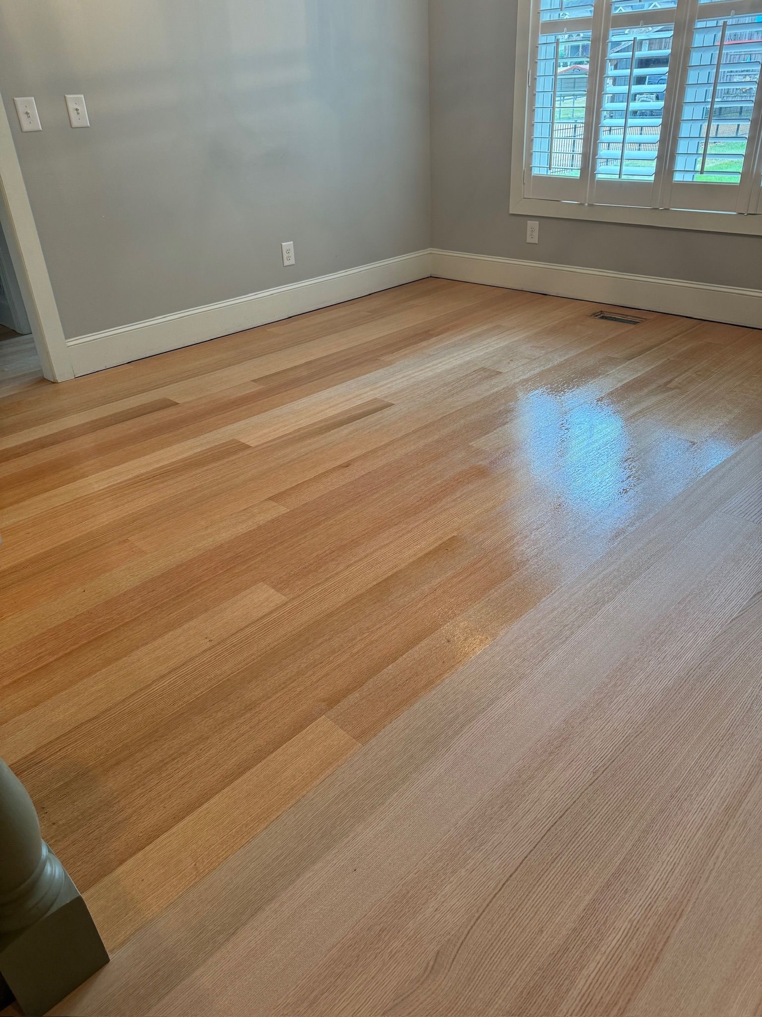 A room with hardwood floors and a window.
